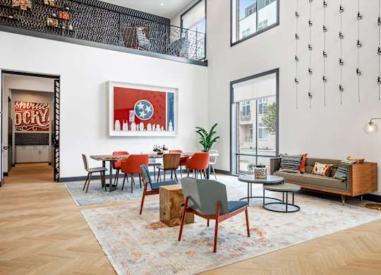 a living room with high ceilings and a dining area with a table and chairs
