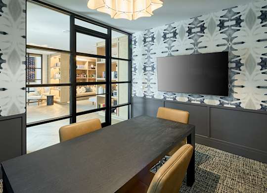 A modern dining room with a large table and chairs.
