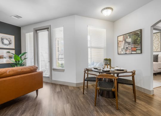 a dining area with a wooden table and chairs and a leather couch