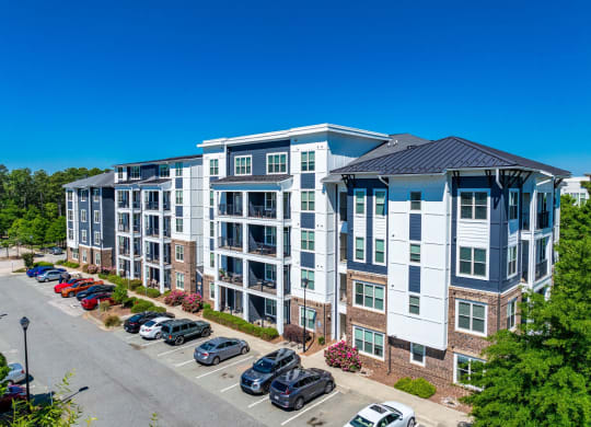 an aerial view of an apartment building with cars parked in a parking lot