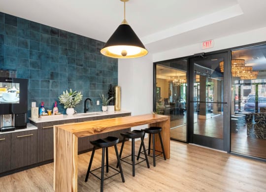 a kitchen with a wooden bar and black stools