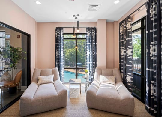 a living room with a couch and a chair in front of a pool