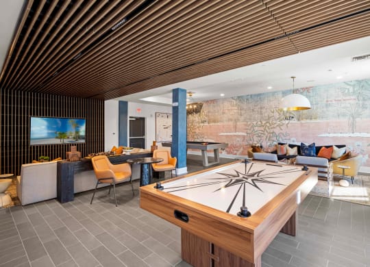 a living room with a pool table and a wall mural