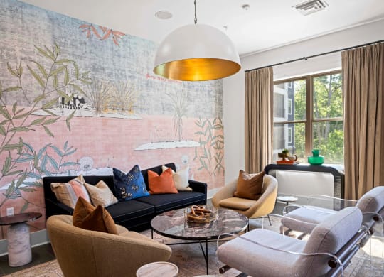 a living room with a couch and chairs and a large wall mural