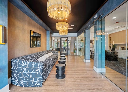 a long blue and white lobby with large beds and chandeliers