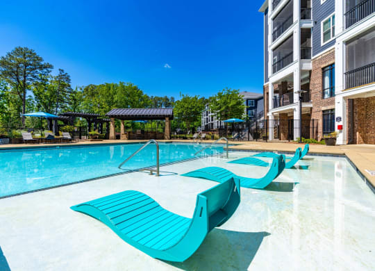 our apartments offer a large swimming pool with blue lounge chairs