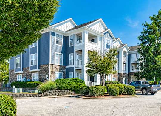 A large apartment building with a parking lot in front.