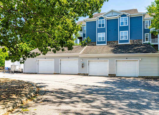 A blue house with white garage doors.
