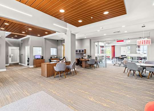 A spacious office with a variety of furniture and a wooden ceiling.