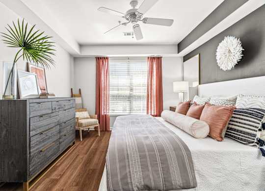 A bedroom with a large bed and a ceiling fan.