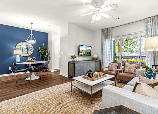 A living room with a white couch, a coffee table, and a television.