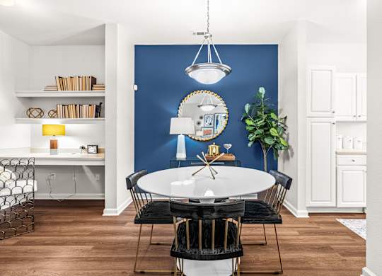 A dining room with a round table and chairs.