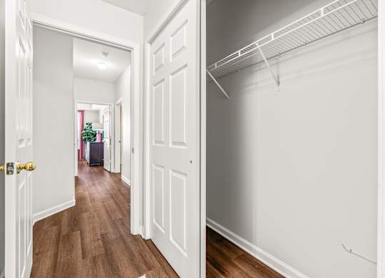 A hallway with a white door and a white wall.