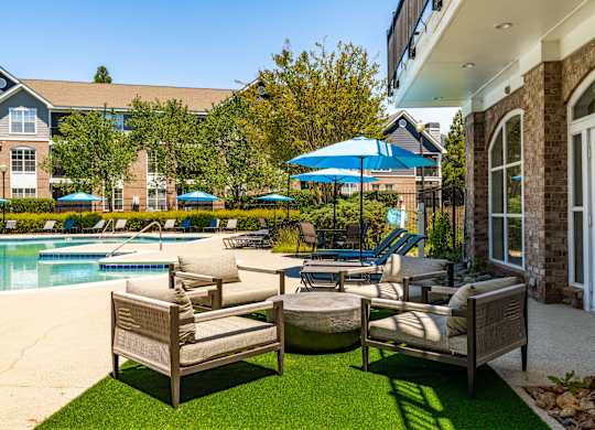 A poolside area with chairs and umbrellas.
