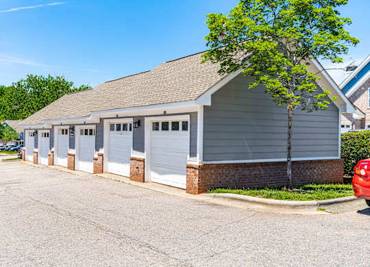 A building with a grey roof and white garage doors.