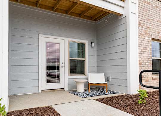 a white chair sits on a blue rug in front of a white door