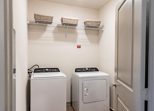 a laundry room with two washers and a dryer