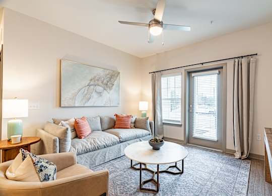 a living room with a couch coffee table and sliding glass doors