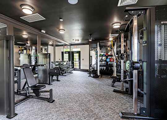 A gym with a variety of equipment including weights and machines.