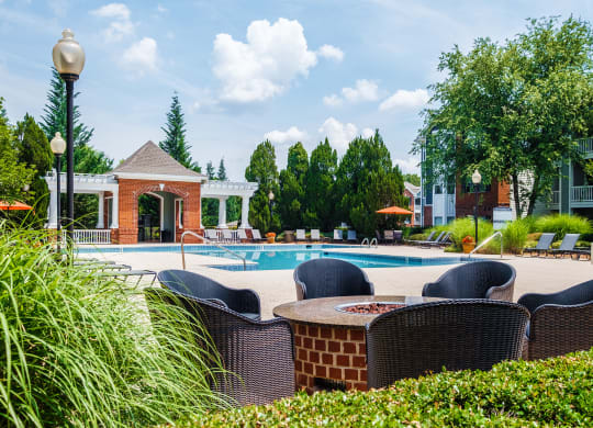 a swimming pool with chairs and a poolside table