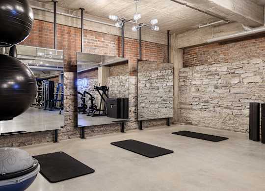 the gym has exposed brick walls and a large exercise ball and rugs