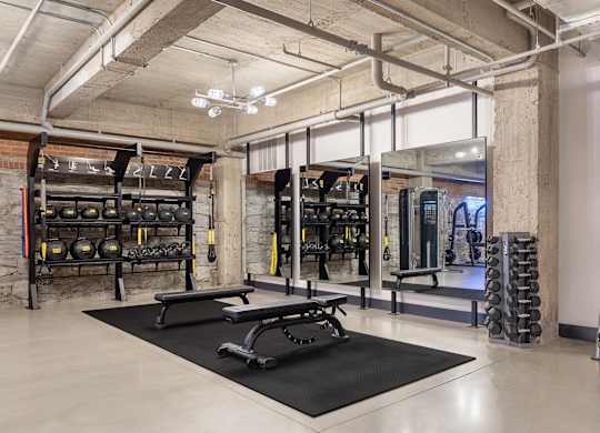 a gym with weights and dumbbells in a loft space