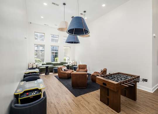 A living room with a foosball table and a couch.