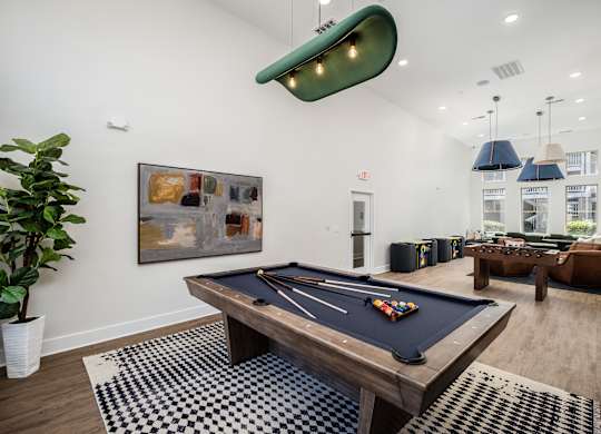 A pool table in a room with a painting on the wall.