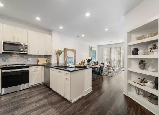 a kitchen with white cabinets and a black counter top