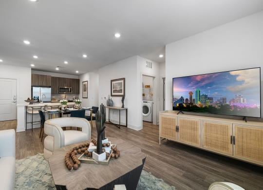 a living room with white walls and wood floors and a dining room table and chairs