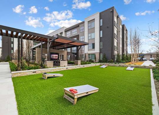 a grassy area with benches in front of some buildings