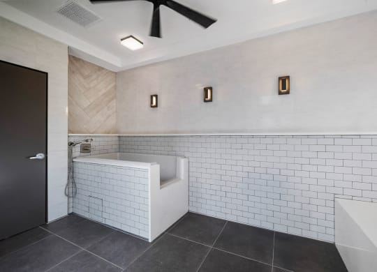 a bathroom with white tiles and a tub and a sink