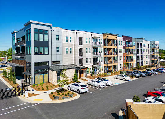 an aerial view of an apartment complex with a parking lot