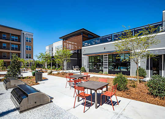 a patio with tables and chairs in front of a building