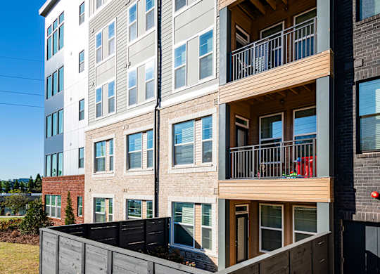 an apartment building with a wooden fence in front of it