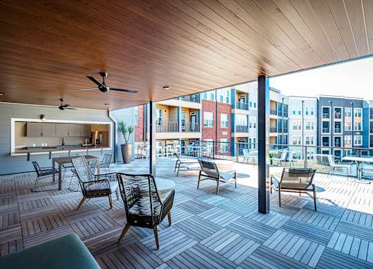 a large deck with chairs and a kitchenette