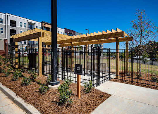 a black fence with a wooden pergola in front of a building