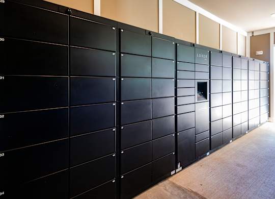 A wall of black lockers with numbers on them.