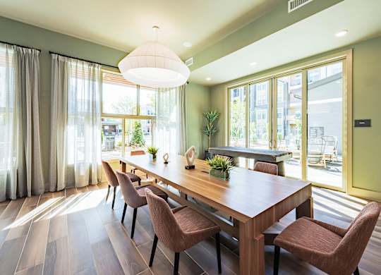 a dining room with a long wooden table and chairs