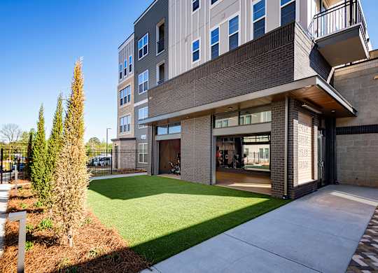 a view of the leasing office and landscaping at the flats at big tex apartments in san