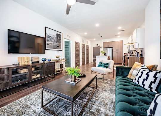 a living room with a green couch and a tv on the wall
