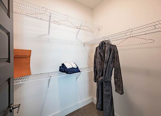 a walk in closet with a robe hanging on the wall