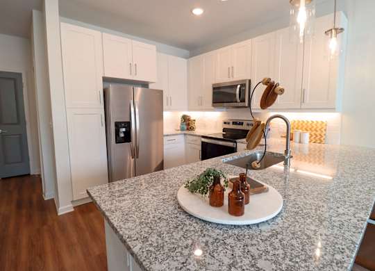 a kitchen with white cabinets and a granite counter top