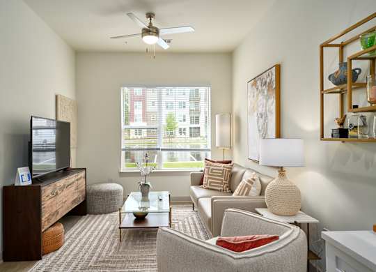 A living room with a couch, armchair, and television.