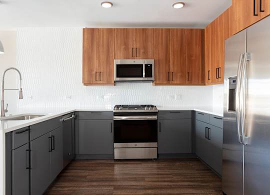 a modern kitchen with stainless steel appliances and wooden cabinets