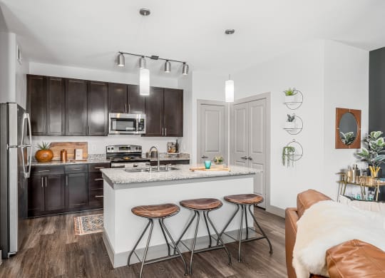 large kitchen with stainless steel appliances, island with breakfast bar seating area