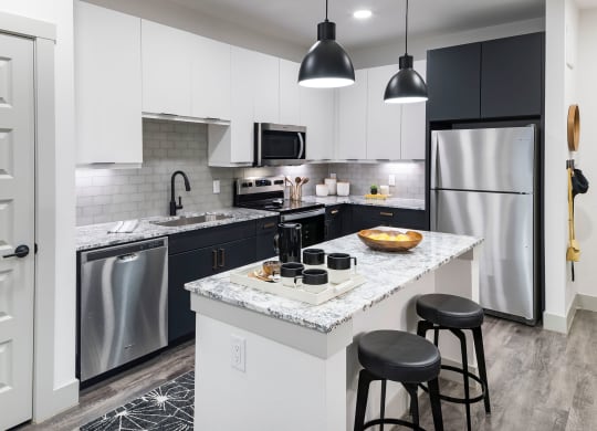 a kitchen with a large island and stainless steel appliances