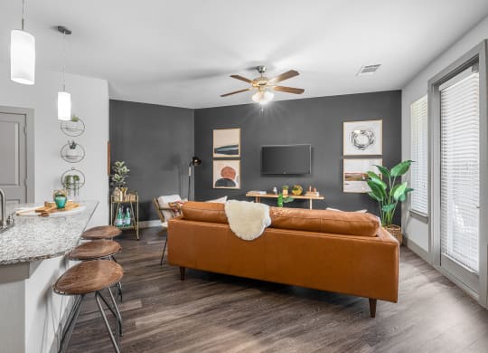 breakfast bar area overlooking living area with sofa, tv and art on the walls