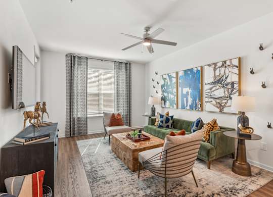 A living room with a green couch, a wooden coffee table, and a painting on the wall.