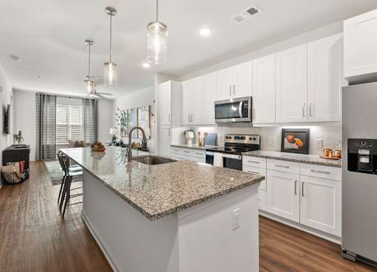 A modern kitchen with a granite countertop and stainless steel appliances.